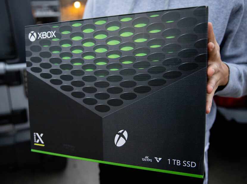 George Garrido holds his Xbox Series X after waiting in line since 3 p.m. yesterday to buy it.