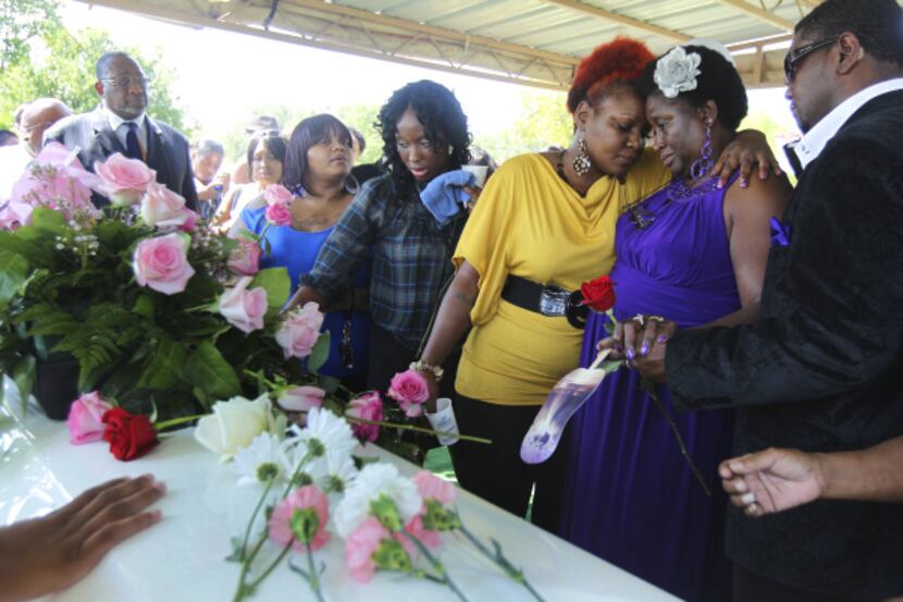 Vickie Cook (second from right) is comforted at the grave site of her daughter Deanna Cook,...