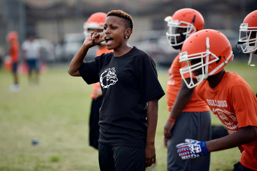 Football coach Desiree Allen yells instructions to players as they work on drills during a...
