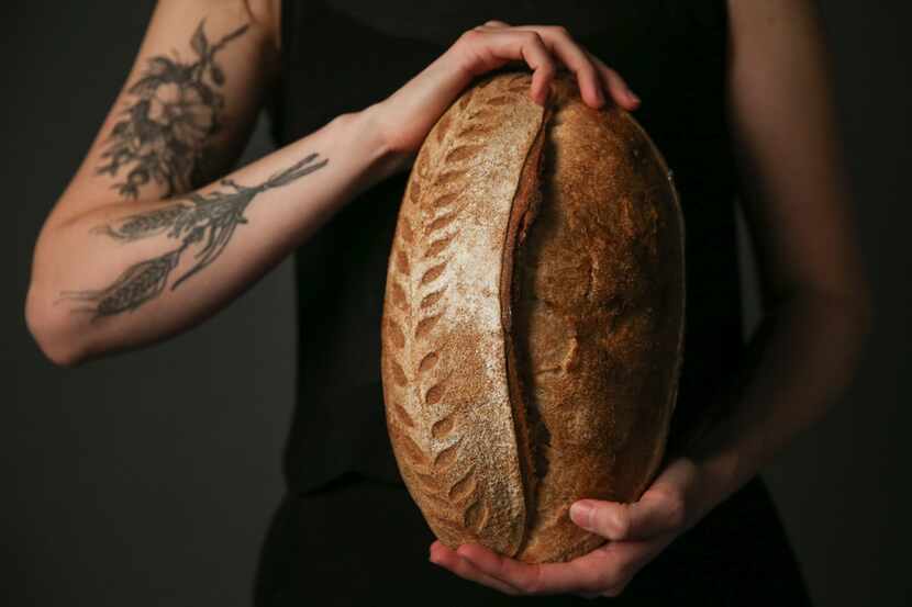 Brooke Carter of Rosemary Bakery is photographed holding loaves of fresh sourdough bread on...