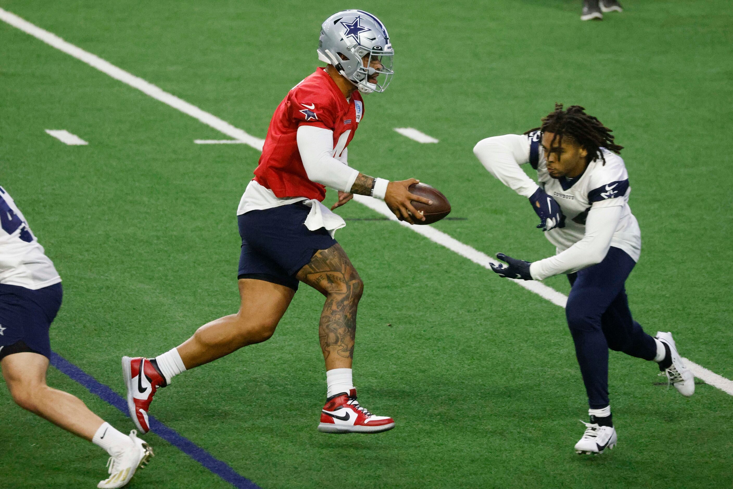 Dallas Cowboys quarterback Dak Prescott (left) passes the ball to running back Malik Davis ...