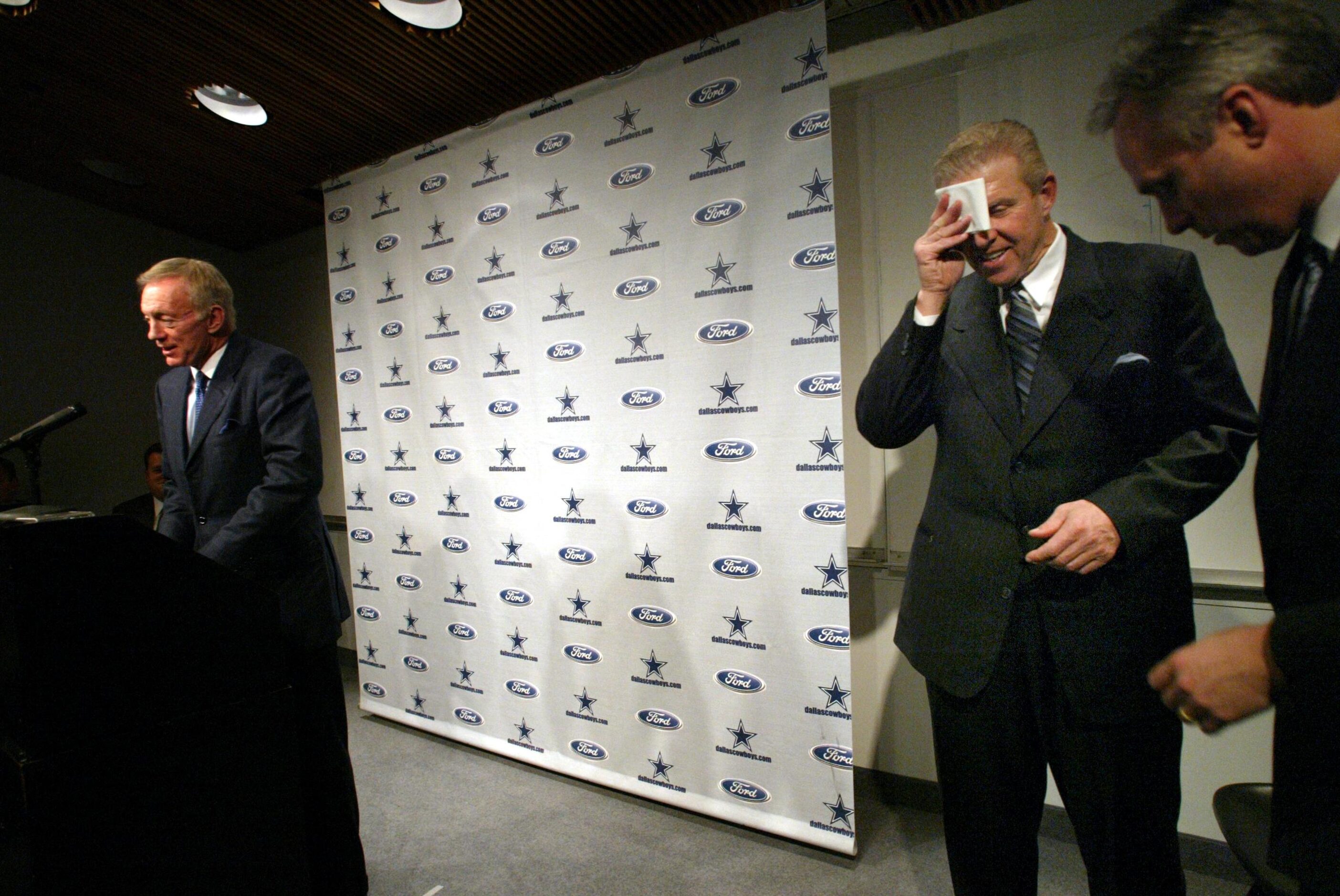 Newly hired Dallas Cowboys head coach Bill Parcells (right) wipes his brow after answering...