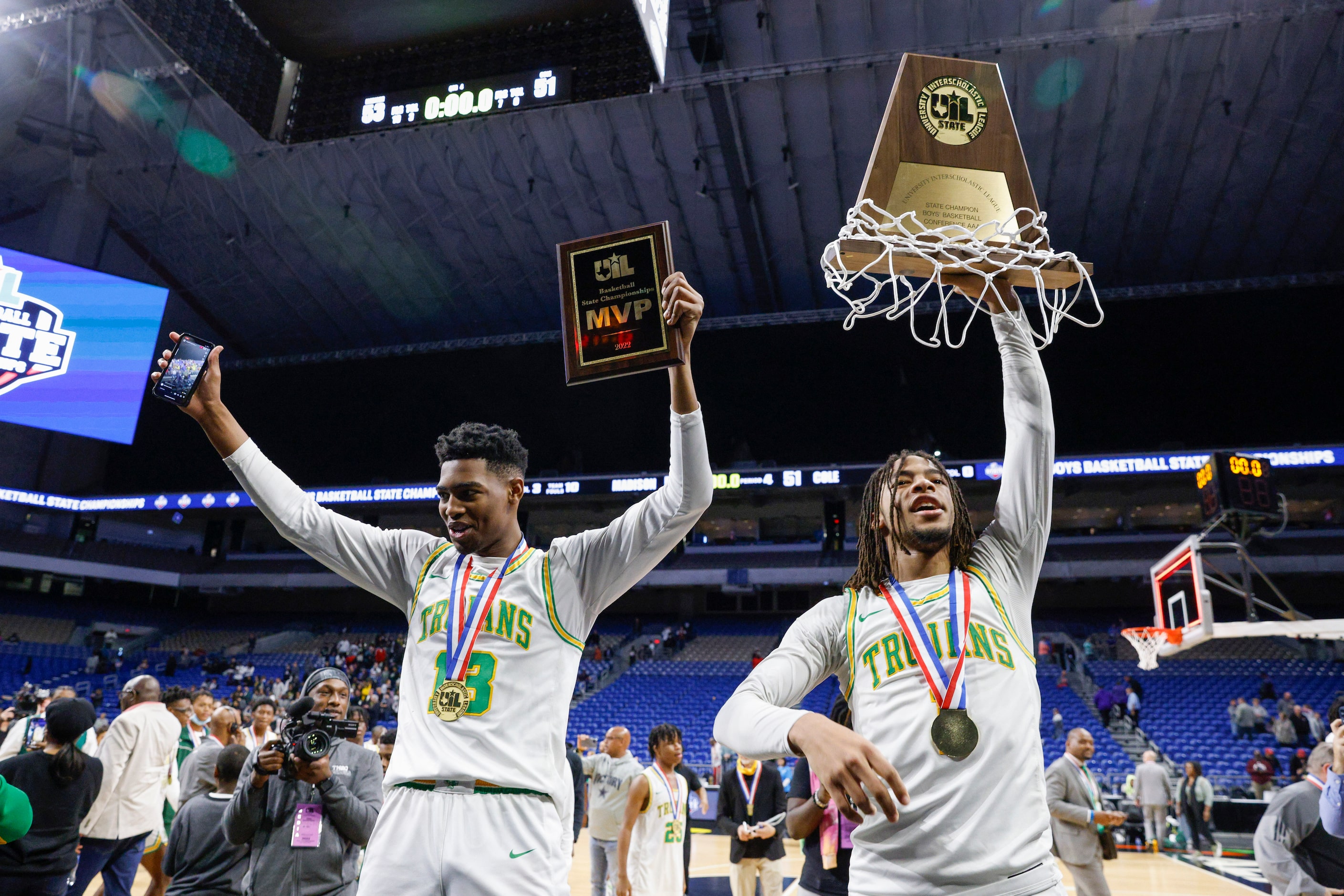 Madison forward Rodney Geter (13) raises the MVP trophy alongside Madison guard Pierre...