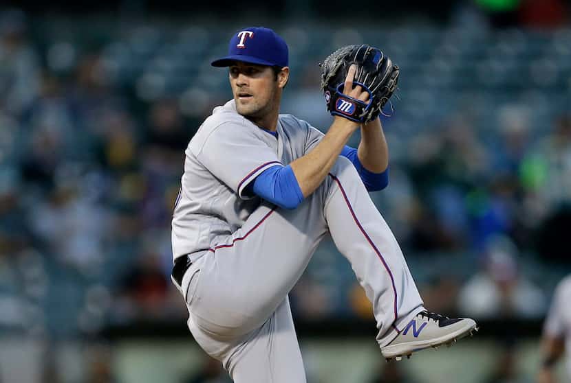 Texas Rangers pitcher Cole Hamels works against the Oakland Athletics in the first inning of...