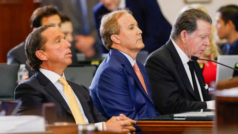 Texas Attorney General Ken Paxton (center) sits with his lawyers Tony Buzbee (left) and Dan...