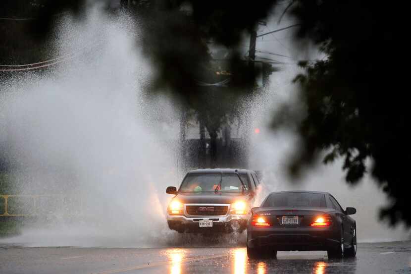 Motorists navigate standing water on North Davis Drive in Arlington. Heavy rains produced as...
