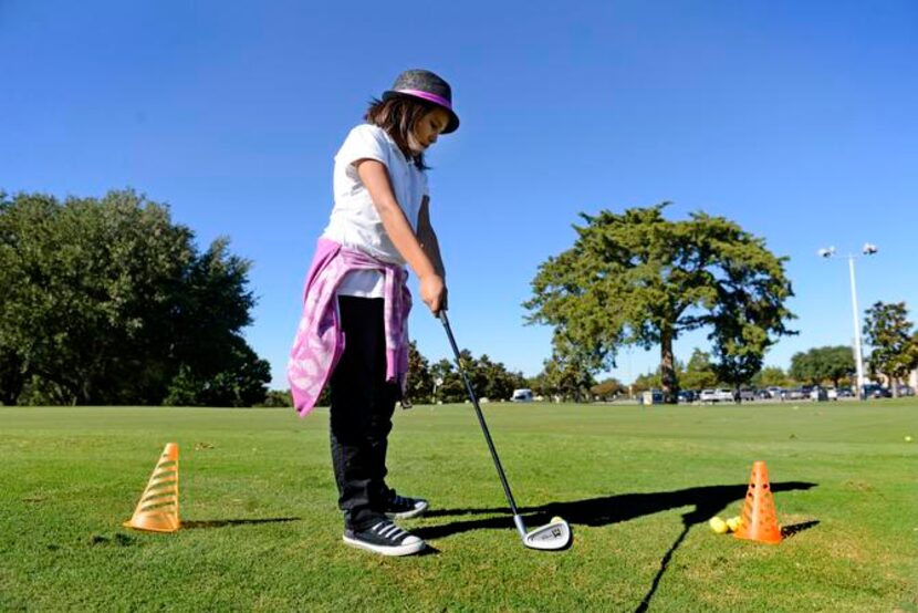 
Samantha Ruiz, 10, a student at Charles Rice Learning Center, takes a swing during a golf...