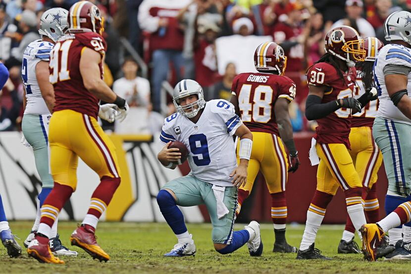 Dallas Cowboys quarterback Tony Romo (9) gets up after being sacked by the Washington...