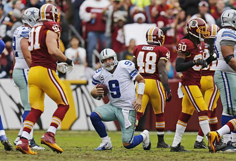 Dallas Cowboys quarterback Tony Romo (9) gets up after being sacked by the Washington...