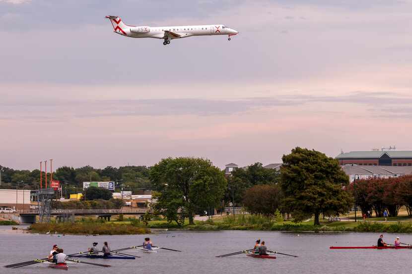 A jet flies over Bachman Lake as it prepares to land at Dallas Love Field airport on...