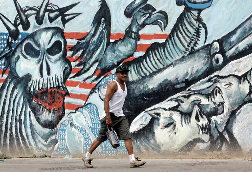 Un hombre camina por un grafiti anti-estadounidense en Caracas el 12 de septiembre de 2008....