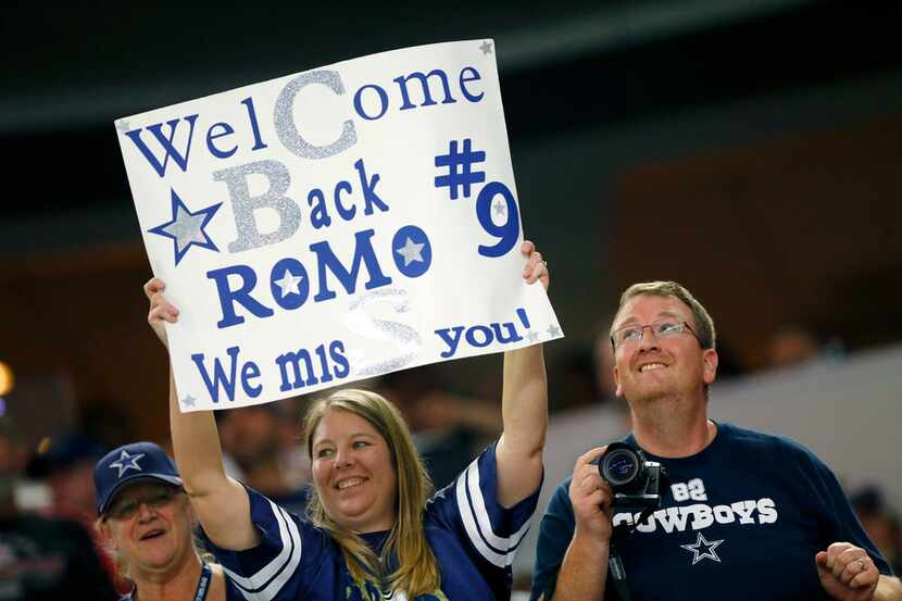 FILE - A Dallas Cowboys fan welcomes former quarterback Tony Romo back to AT&T Stadium...