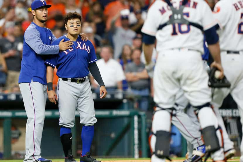 HOUSTON, TX - MAY 01:  Shin-Soo Choo #17 of the Texas Rangers is restrained by Yu Darvish...