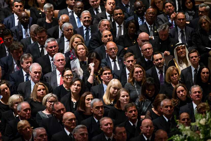 A woman wipes her eyes as former President George W. Bush delivers a eulogy during the State...