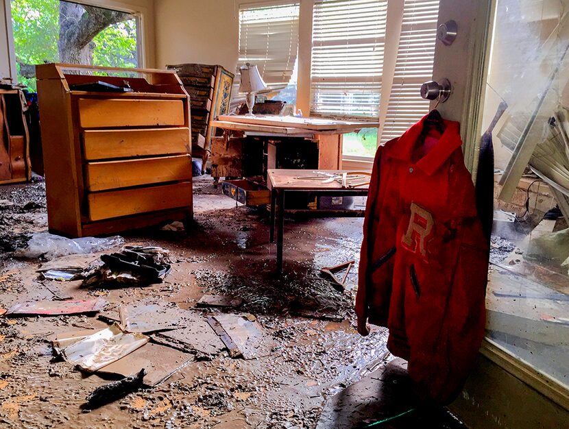  Larry Fick's high school letter jacket is hung up to dry among flood damage in the living...