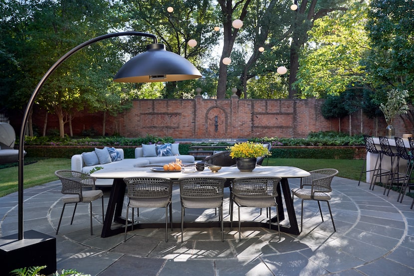 A porcelain-topped dining table from Coco Wolf and dining chairs from Tribu sit under a heat...