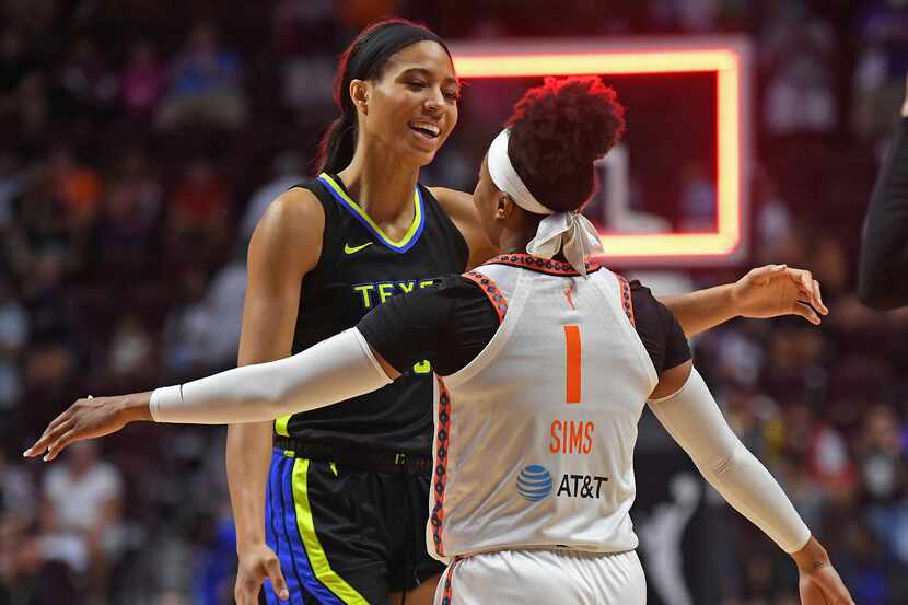Connecticut Sun guard Odyssey Sims (1) embraces Dallas Wings forward Isabelle Harrison (20)...