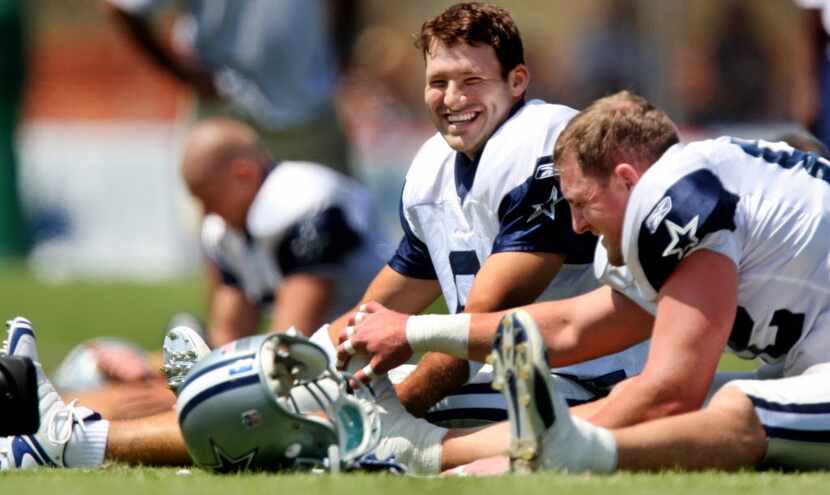Dallas Cowboys QB Tony Romo and TE Jason Witten share a laugh during stretching exercises at...