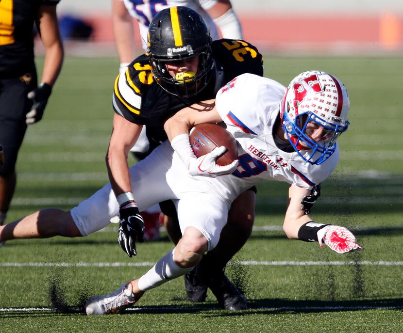 Midlothian Heritage's Jay Wilkerson (8) picks up a first down, amid flying rubber pellets,...
