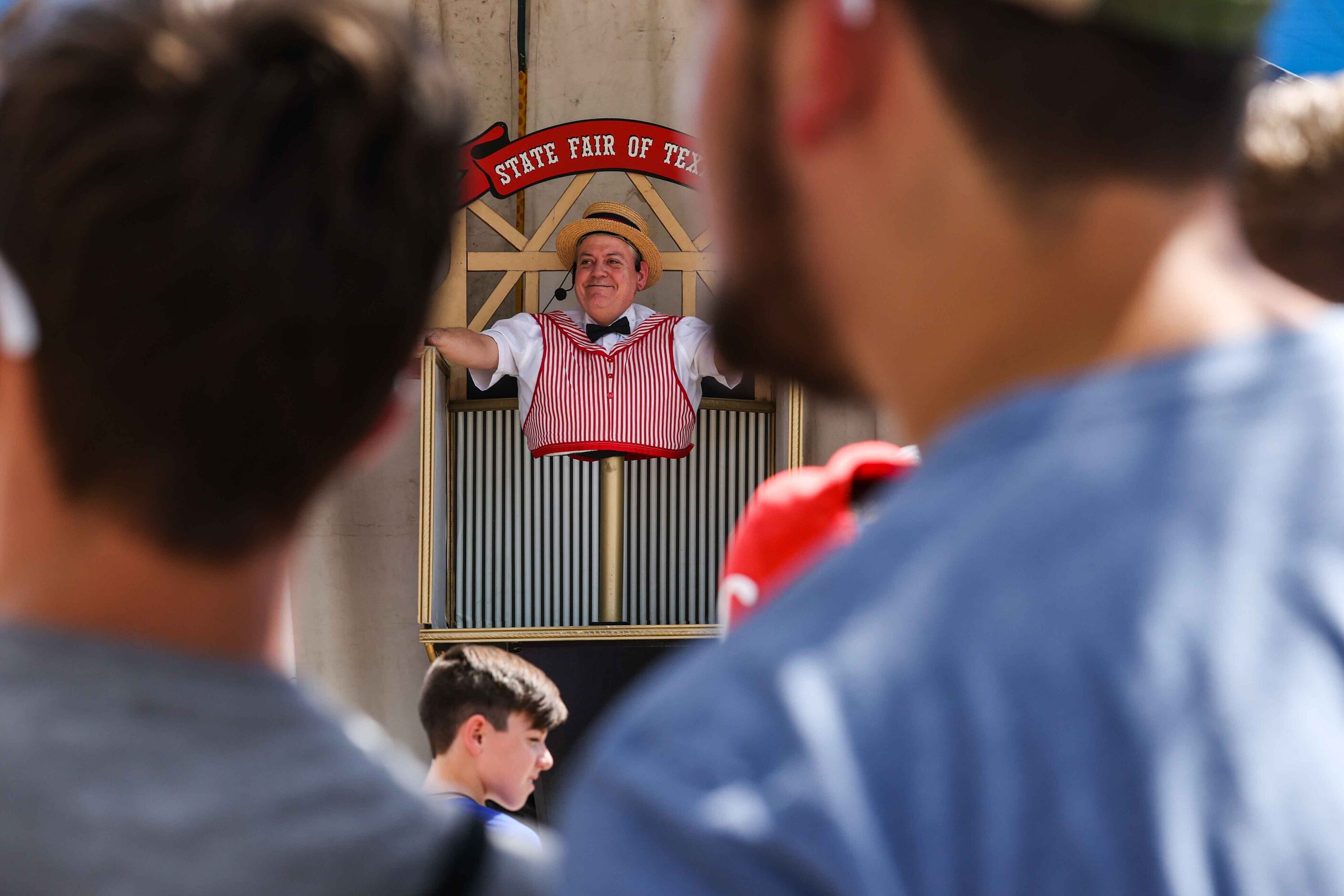 The Midway Barker entertains people at the State Fair of Texas during its opening day in...