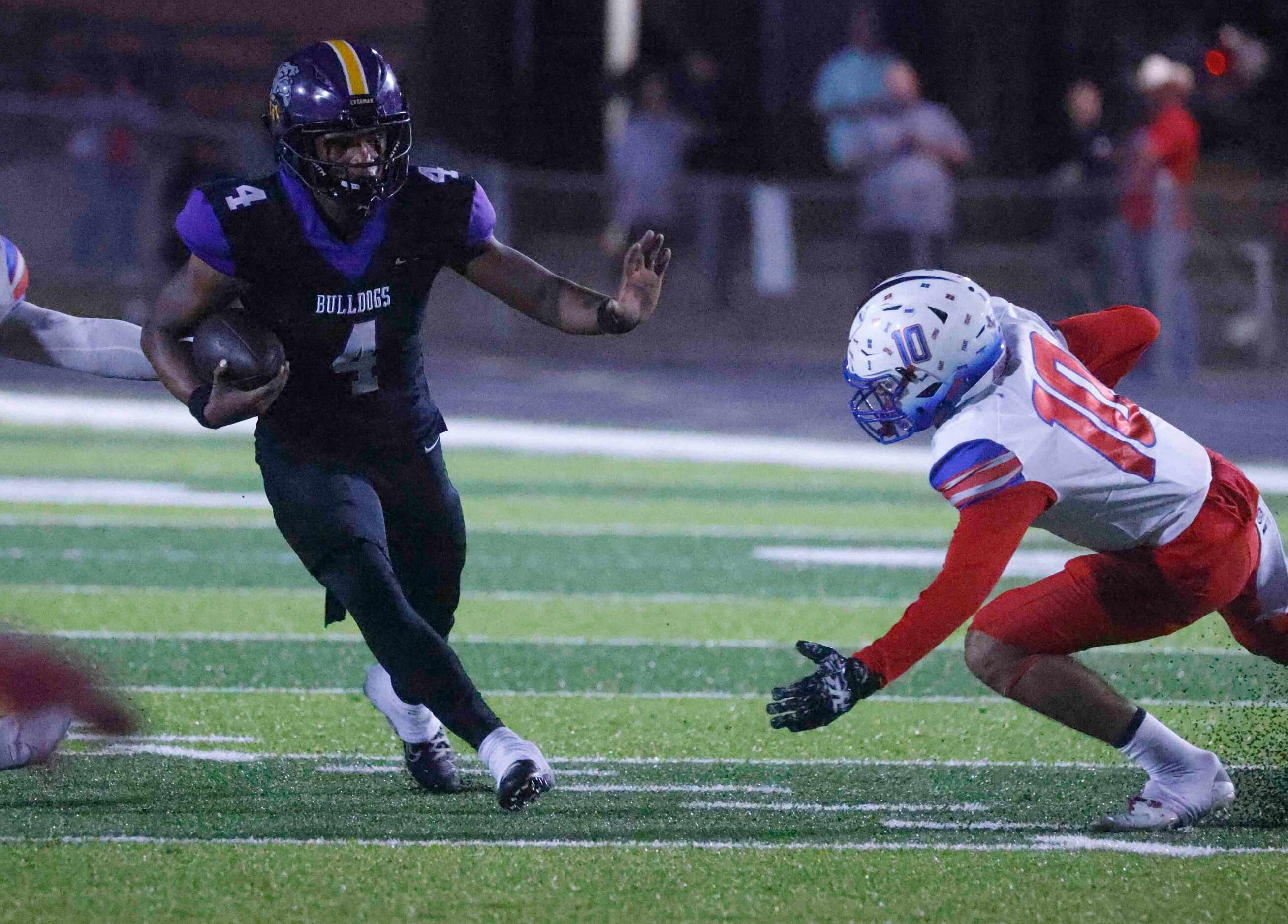 Everman High’s Marion Basped (4) runs past Midlothian Heritage’s Tae Jackson (10) for a...