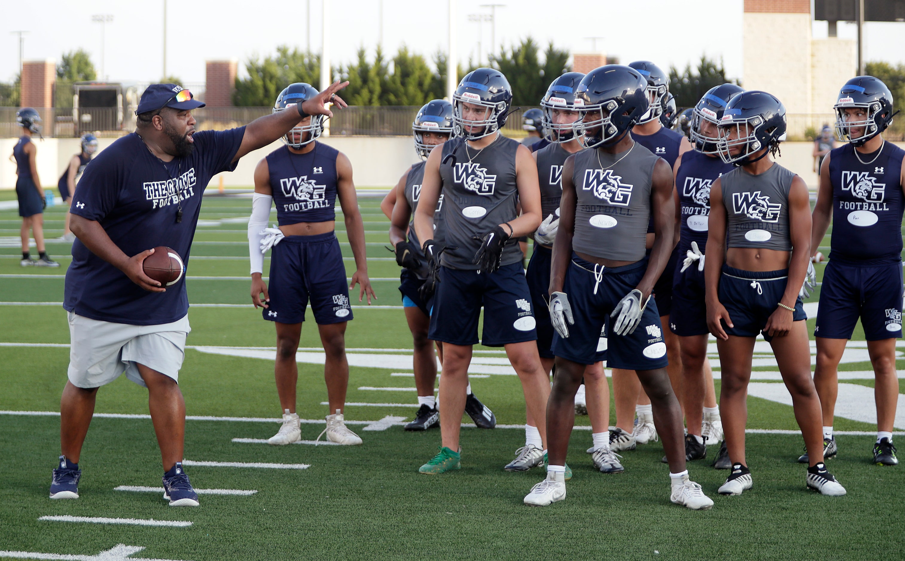 Running Backs Coach Josh Davenport (left) instructs the running backs on the next drill as...