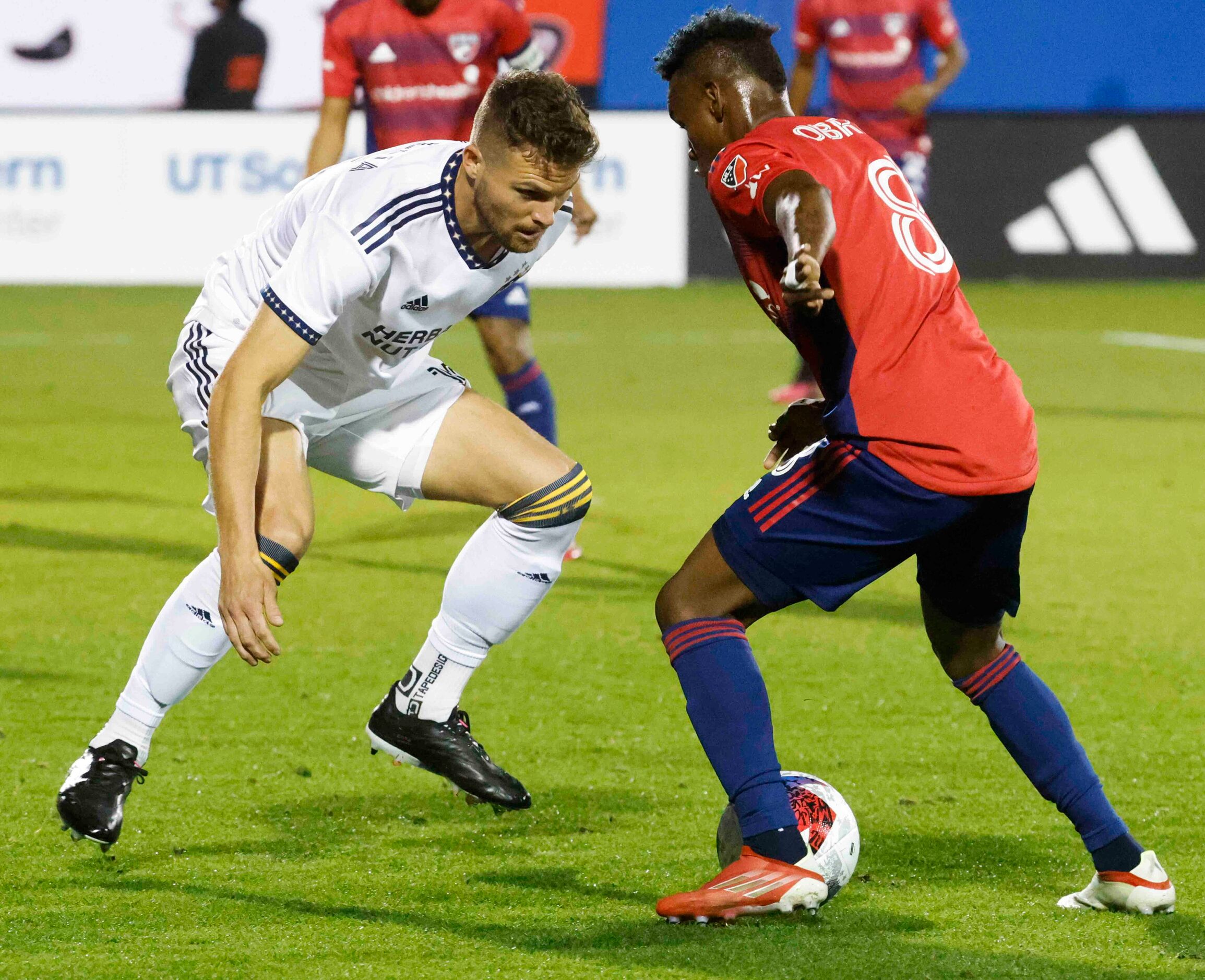 Los Angeles Galaxy defender Eriq Zavaleta (left) observes as FC Dallas forward Jáder Obrian...