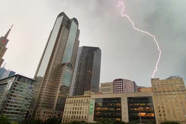 Lightning appears to hit the top of Hotel Indigo as an approaching thunderstorm moved over...