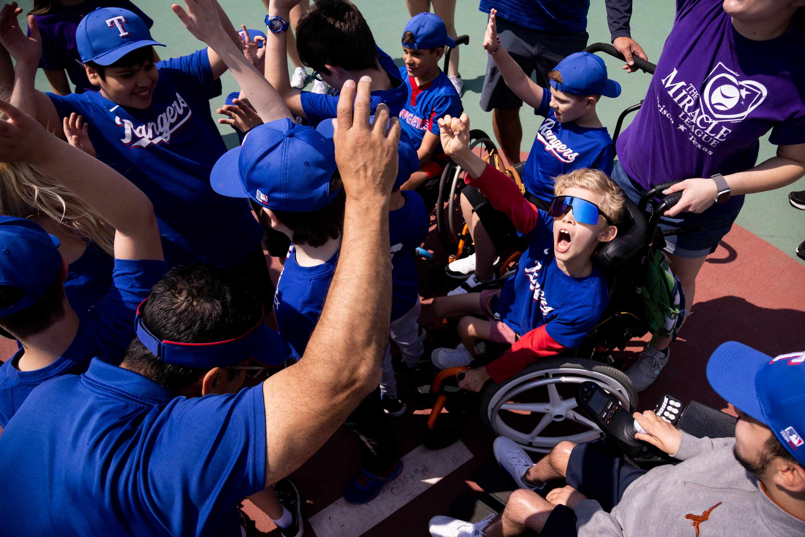 Will Woleben, 11, celebrates in a huddle at the end of a Miracle League Baseball Game at the...