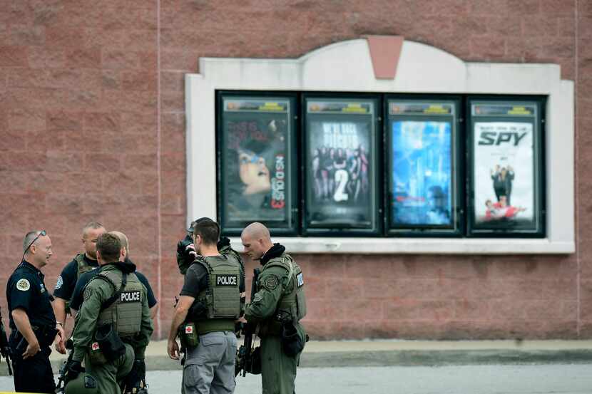 Nashville Metro Police officers talk in front of a display of movie theater posters...