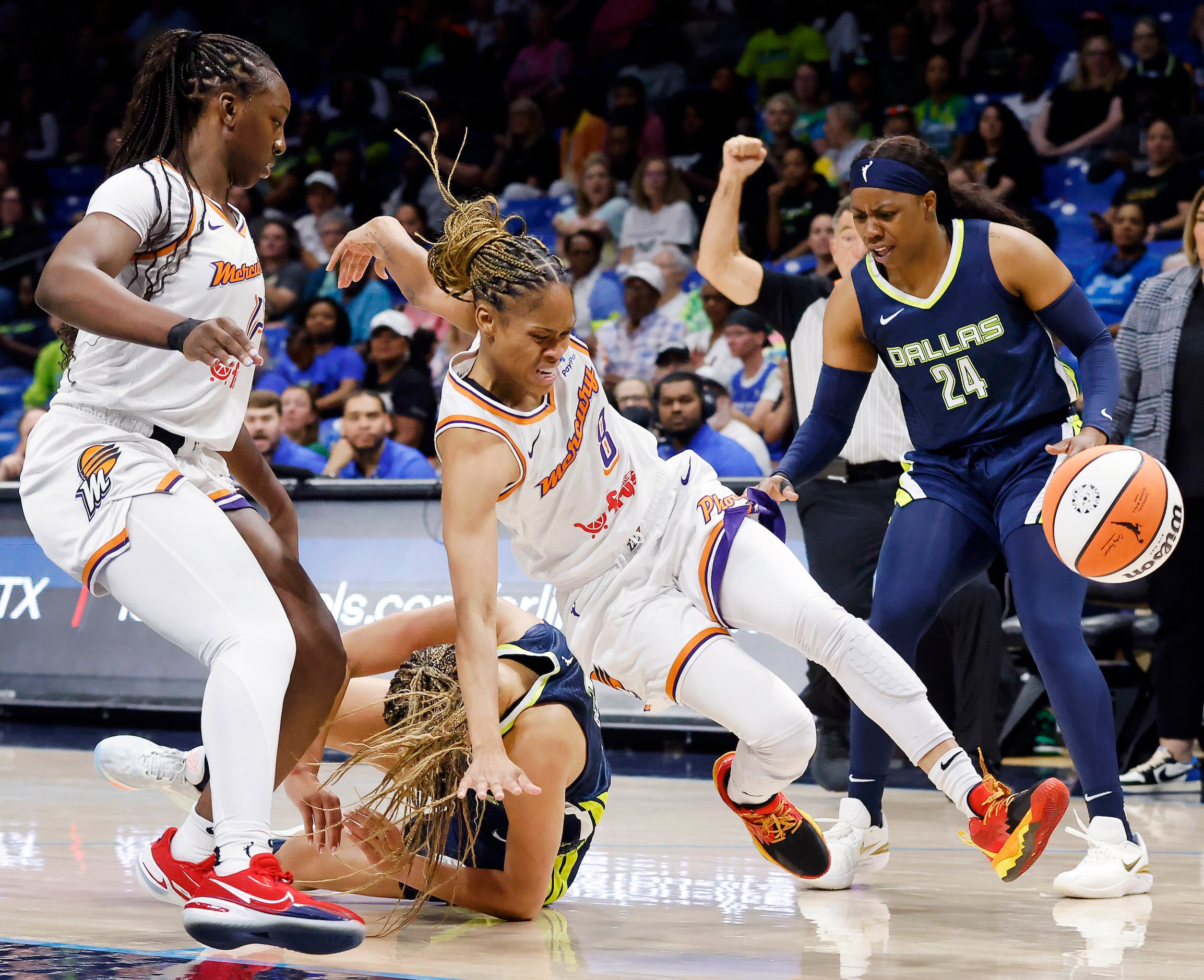 Phoenix Mercury guard Moriah Jefferson (8) is sent flying by Dallas Wings guard Veronica...