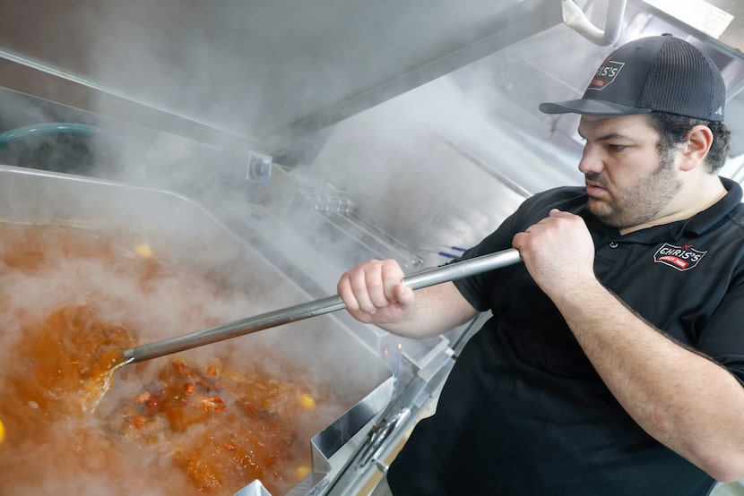 William Durand, owner of Chris's Specialty Foods, stirs a pot of crawfish in Frisco. 