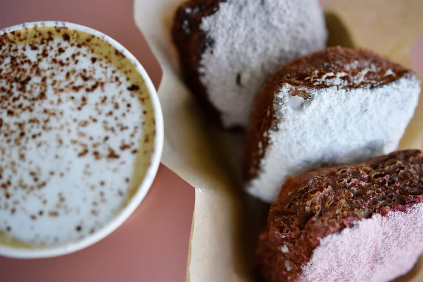 A vanilla latte and an order of Le Boneignets with strawberry, classic and chocolate powder,...