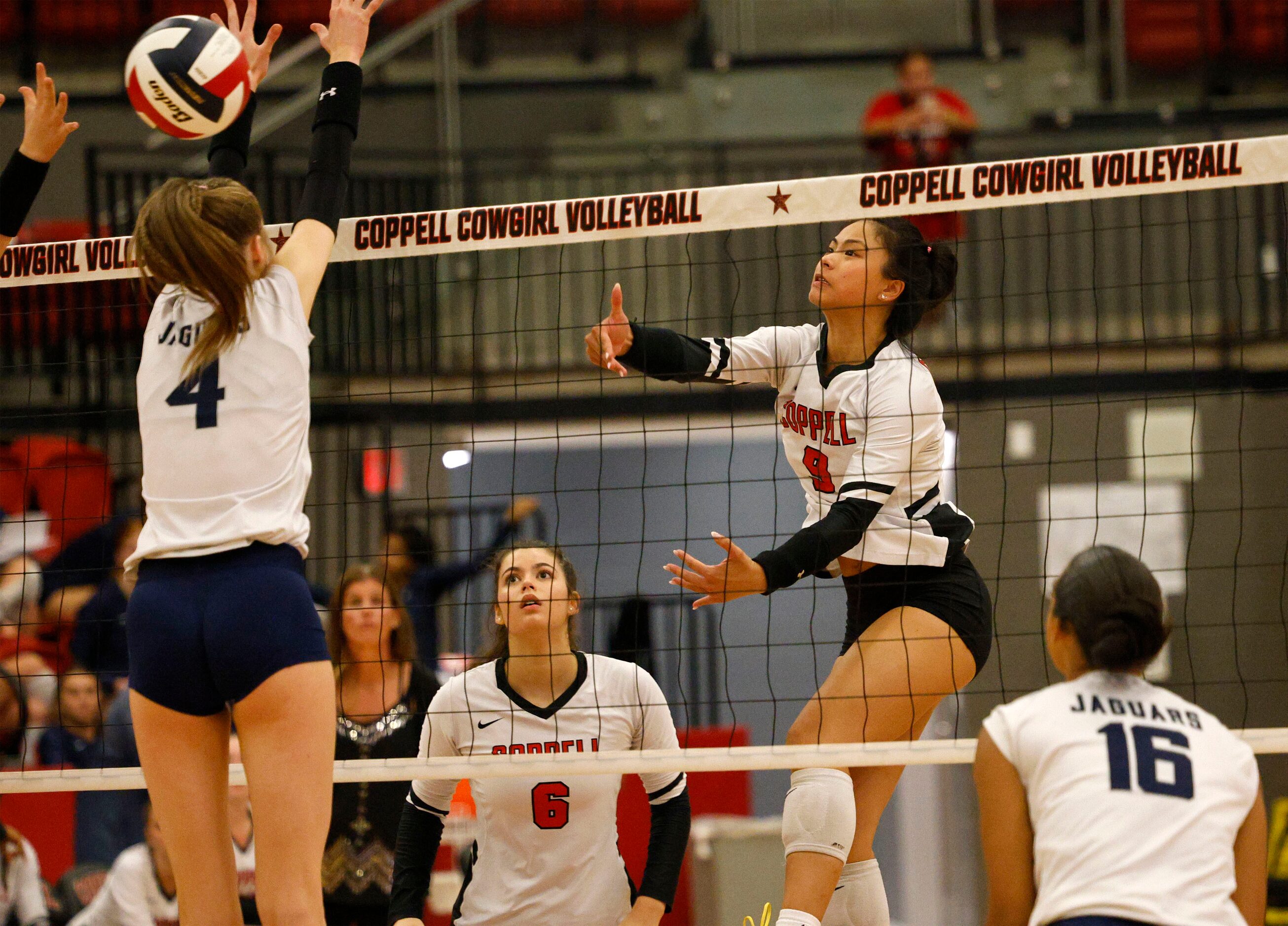 Coppell's Coppell's Alena Truong (9) spikes the ball as Flower Mound's Caroline Tredwell (4)...