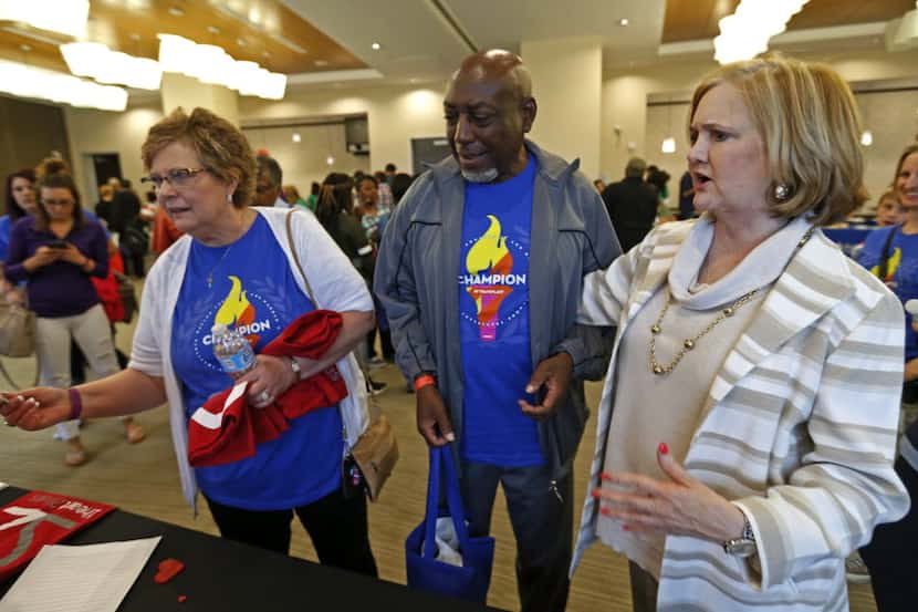 Judy Thompson (left) gets a T-shirt as Lowry Briley (center) and Kay Keeland look on during...