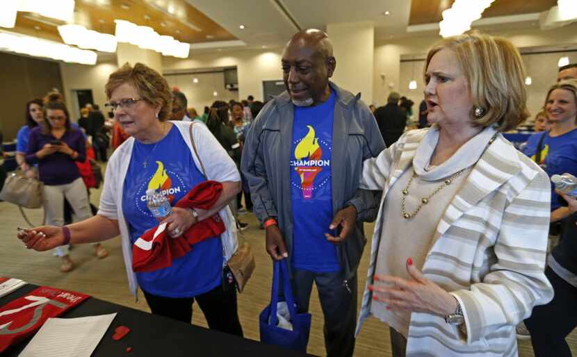Judy Thompson (left) gets a T-shirt as Lowry Briley (center) and Kay Keeland look on during...