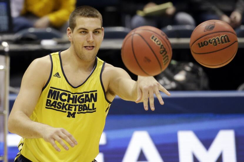 Michigan forward Mitch McGary passes the balls during a practice session for their NCAA...