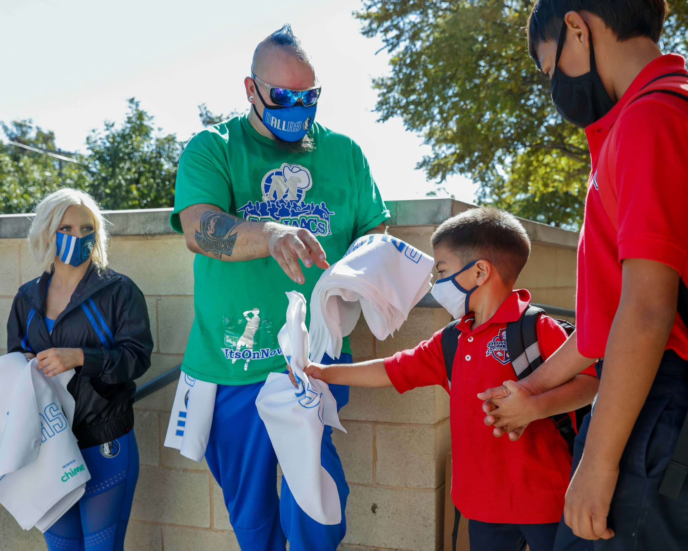 Mavs ManiAACs dancer Pro Zac gives a Dallas Mavericks towel to a student after the end of...