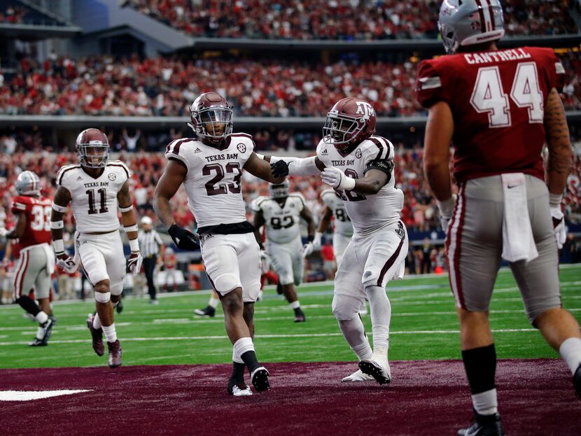 Texas A&M Aggies defensive back Armani Watts (23) is congratulated by linebacker Otaro Alaka...