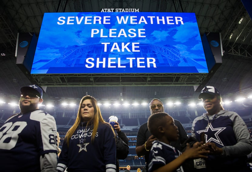 Fans exit the field to protected areas of the stadium during a tornado watch after the...