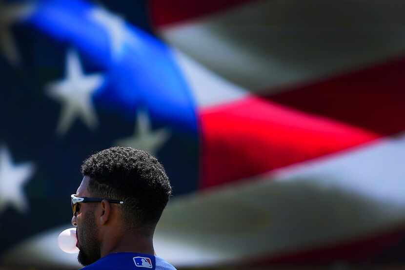 Texas Rangers second baseman Marcus Semien stands for the national anthem before a spring...