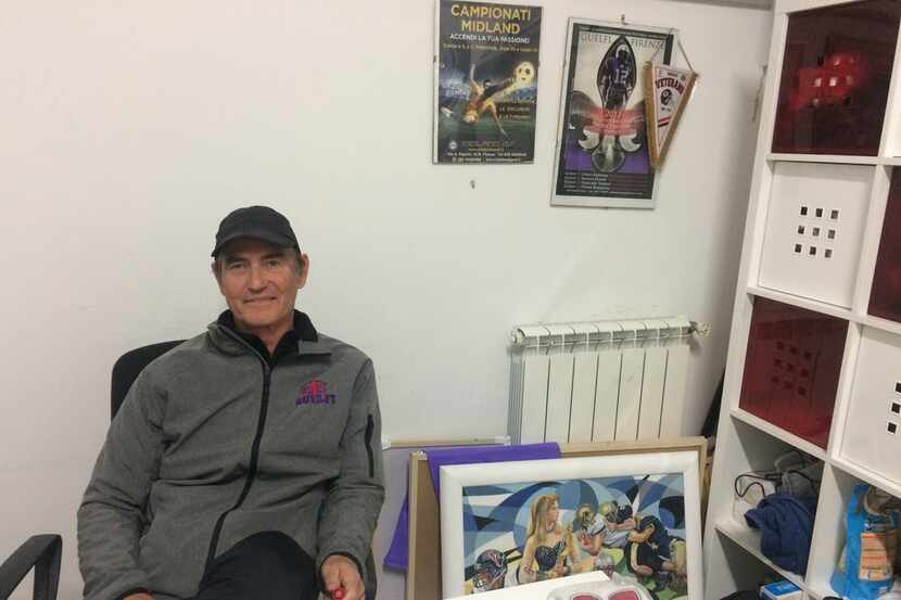 Art Briles poses at his desk in a cramped office.