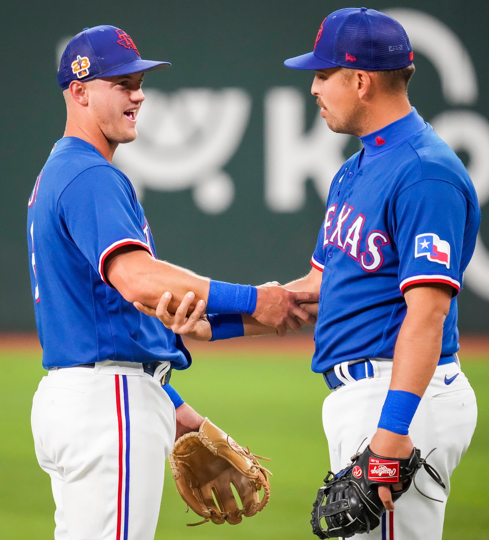 Texas Rangers third baseman Josh Jung (left) locks arms with first baseman Nathaniel Lowe...
