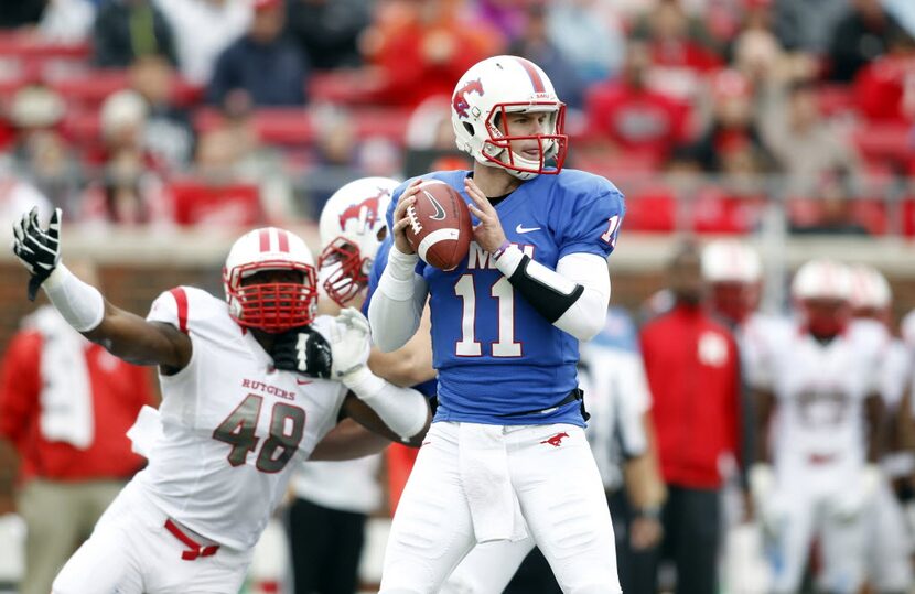 FILE - SMU quarterback Garrett Gilbert (11) looks down field as Rutgers defensive end Marcus...