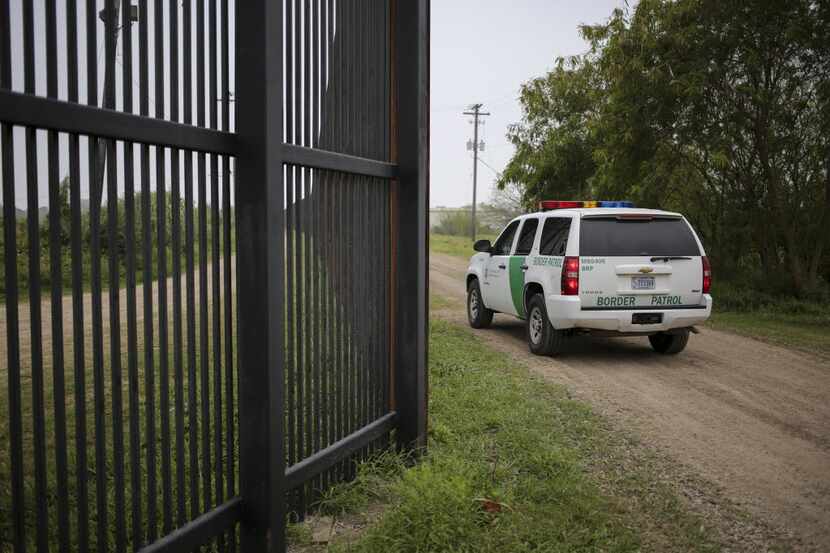 A Border Patrol vehicle patrols a fence near the Rio Grande in Brownsville. (Ilana...