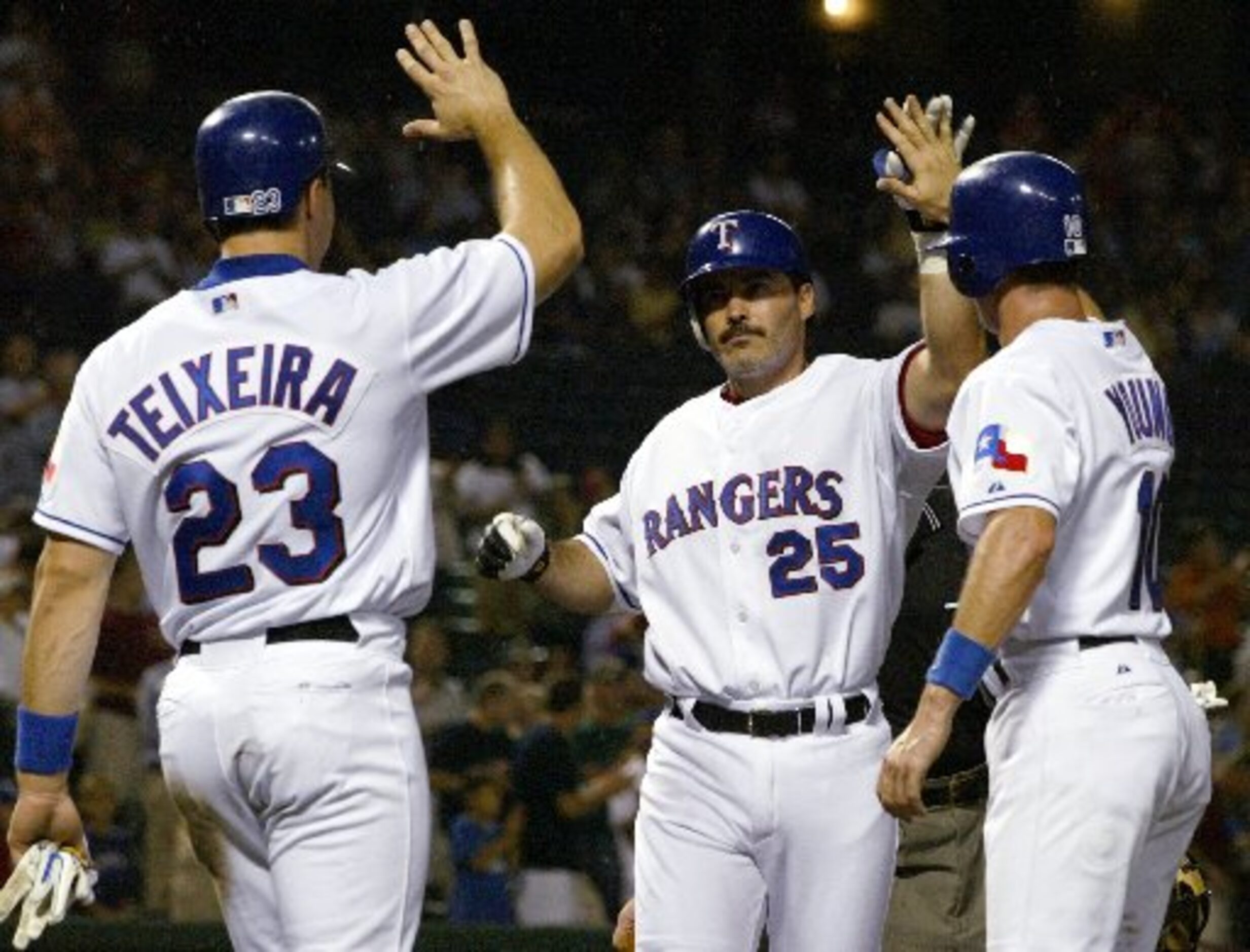 Rangers Rafael Palmerio (25), Mark Teixeira (23) and Michael Young celebrate a home run in...