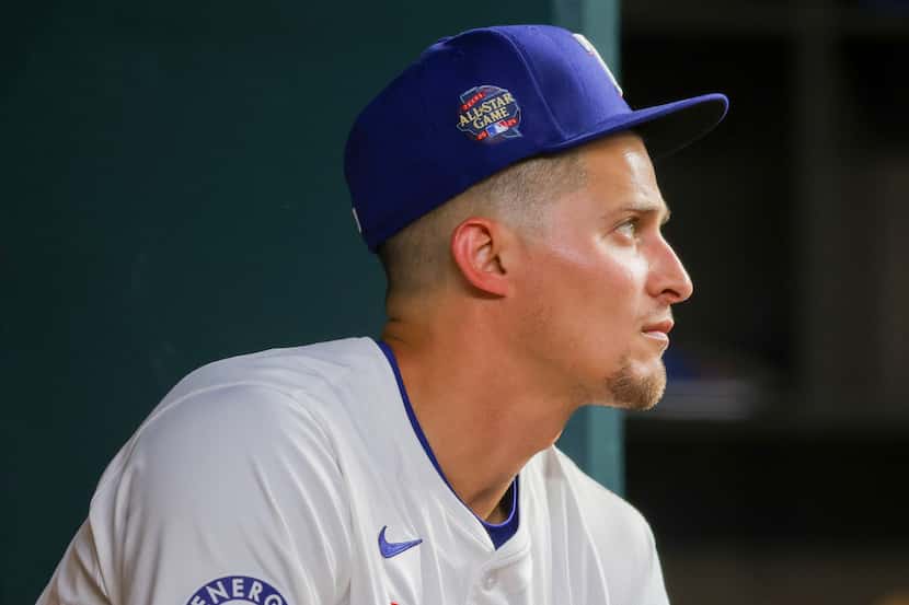 Texas Rangers' Corey Seager sits in the dugout before a baseball game against the Seattle...