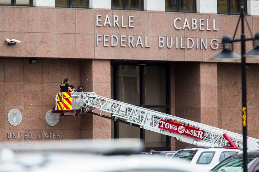 FBI and other law enforcement officials inspect the Earle Cabell Federal Building on Tuesday...