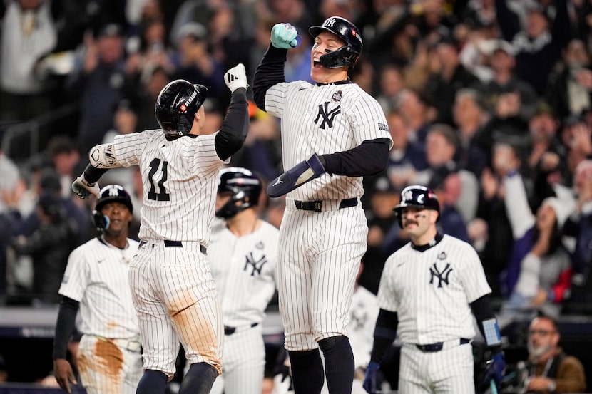 New York Yankees' Anthony Volpe celebrates his grand slam home run with Aaron Judge against...