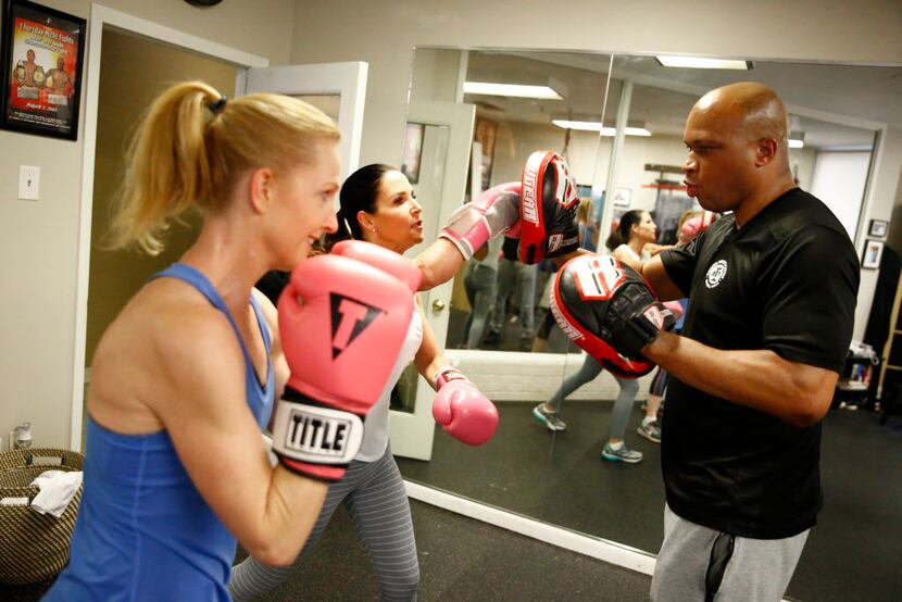 Meridan Zerner (from left) and Cass Wright practice punching with boxing trainer Derrick...
